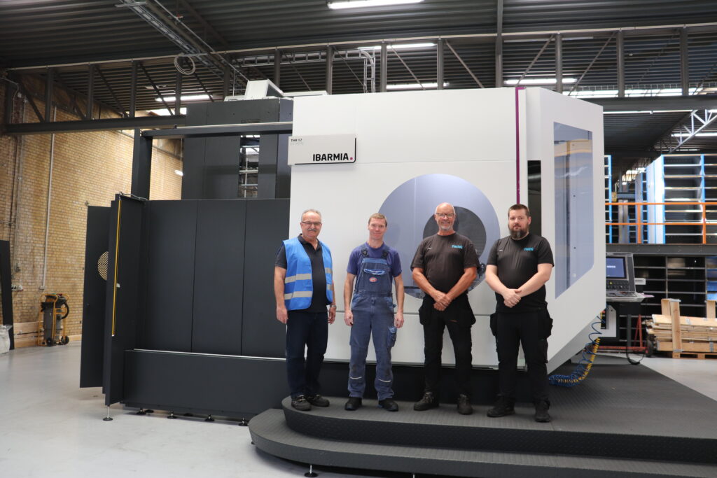 Medarbejdere fra Flextek og HMF Group foran en Ibarmia CNC-maskine som del af et strategisk samarbejde om avanceret bearbejdning.