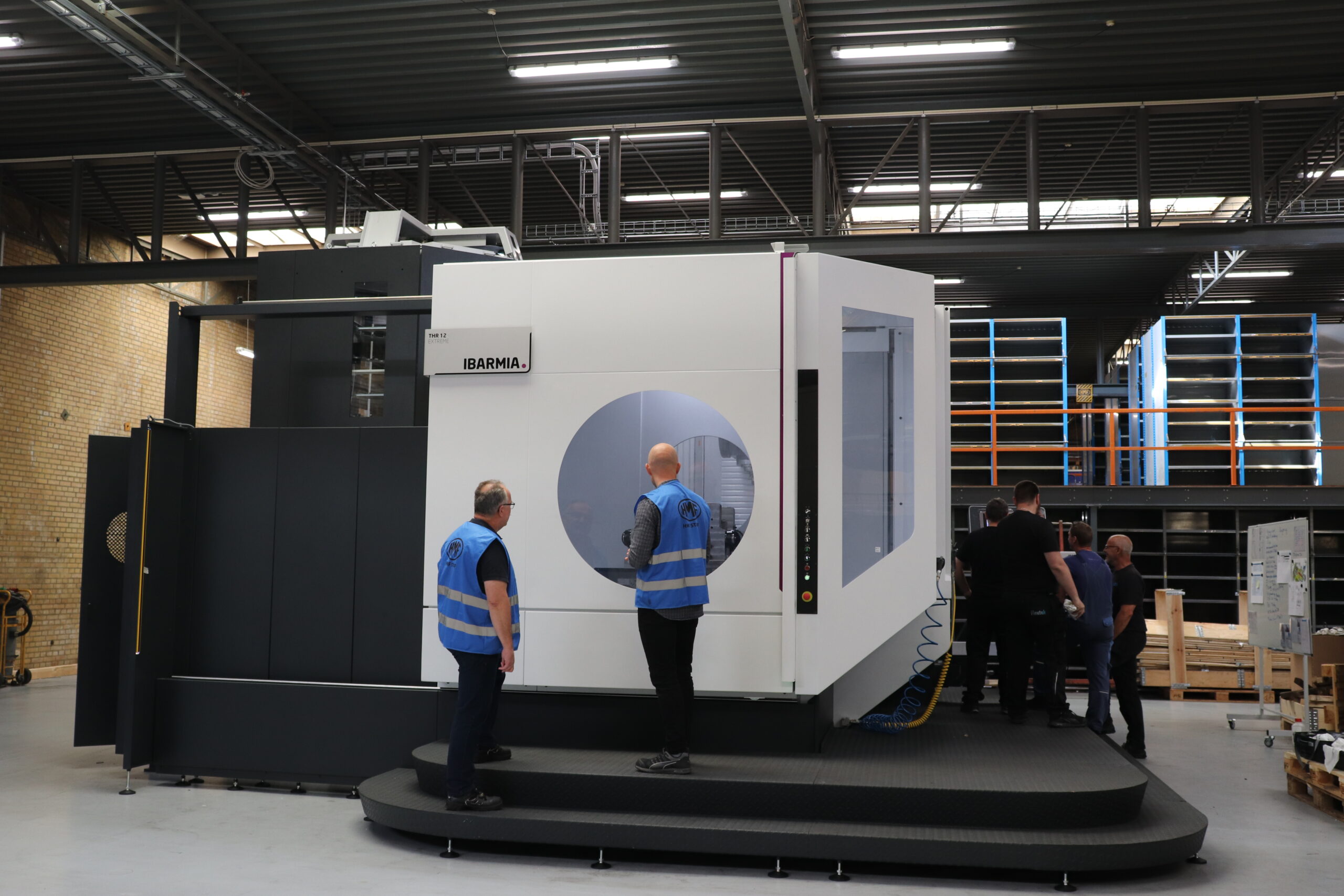 To medarbejdere fra HMF foran nyinstalleret Ibarmia bearbejdningscenter i produktionshallen.
