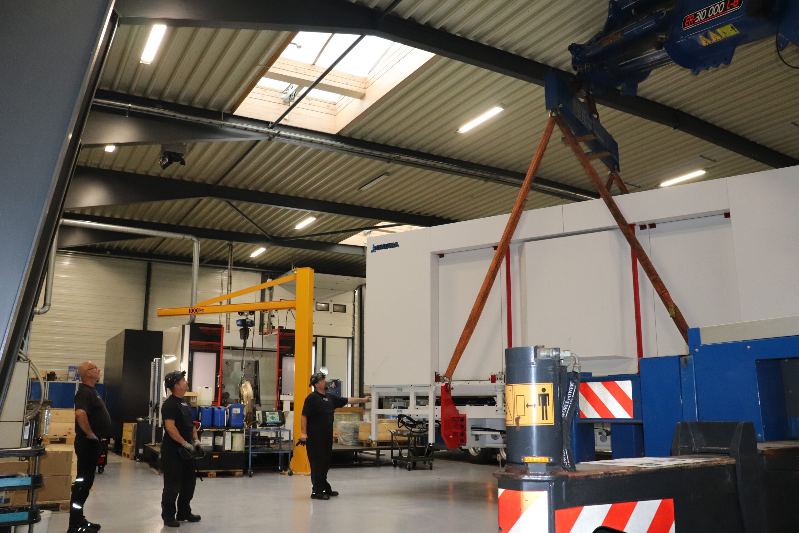 AVK Tooling medarbejdere overvåger installationen af stort Okuma bearbejdningscenter fra Flextek.