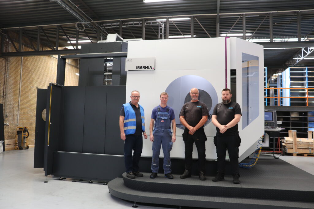 Medarbejdere fra Flextek og HMF Group foran en Ibarmia CNC-maskine som del af et strategisk samarbejde om avanceret bearbejdning.