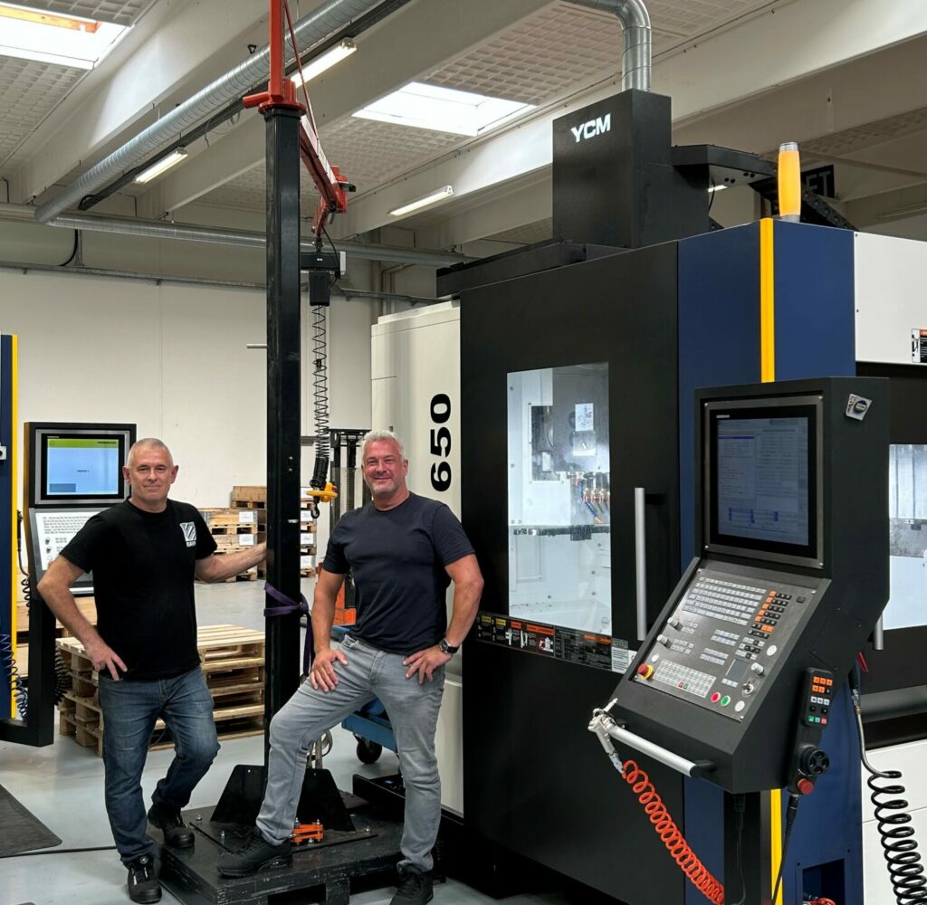 Thomas Ravn og Denis Zubanovic fra Ravn A/S foran deres nye YCM UV650 bearbejdningscenter leveret af Flextek.